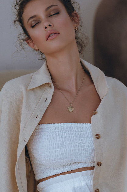 Strapless alabaster smocked bandeau styled with wide leg linen trousers